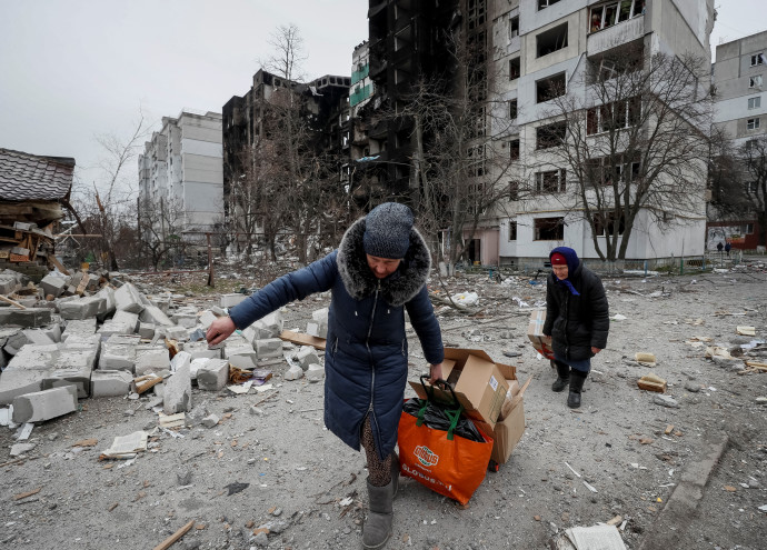 Helyi lakosok élelmiszersegélyt visznek a szétlőtt Borogyankában – Fotó: Gleb Garanich / Reuters