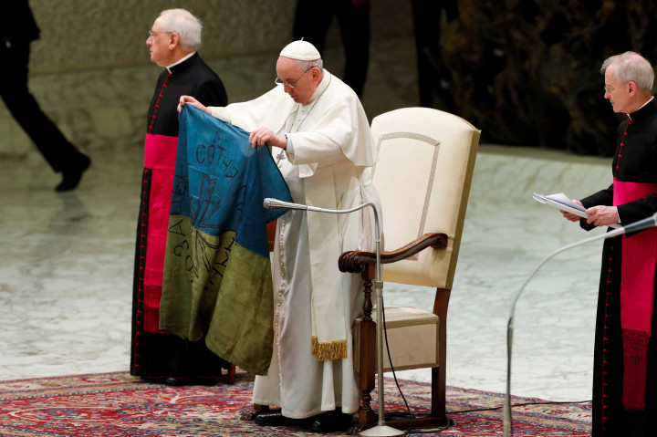 Ferenc pápa kezében egy Bucsából küldött ukrán zászlóval – Fotó: Remo Casilli / Reuters