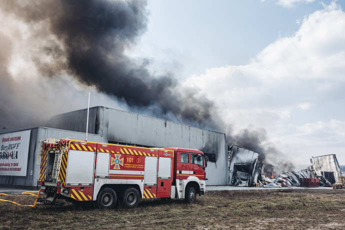 Tűzoltók dolgoznak egy kijevi üzemnél, ami kigyulladt és leégett egy légitámadás után március 24-én – Fotó: Diego Herrera Carcedo / Anadolu Agency / AFP