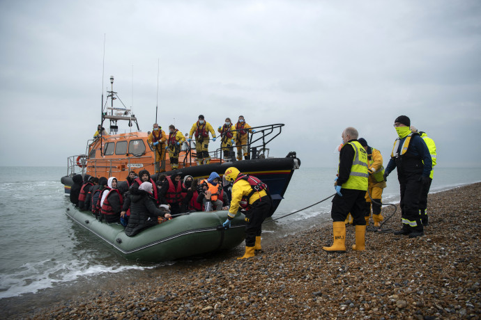 Brit vízimentők segítenek partra egy bevándorlókkal teli gumicsónakot – Fotó: Ben Stansall / AFP