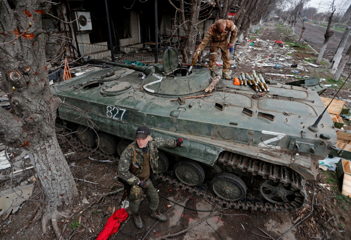 Az oroszbarát csapatok tagjai rakéta-meghajtású gránátokkal töltenek meg egy gyalogsági harcjárművet az Azovsztal Vas- és Acélgyár közelében 2022. április 12-én – Fotó: Alexander Ermochenko / Reuters