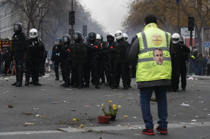 Sárga mellényes tüntető rohamrendőrök előtt Párizsban 2019 decemberében, amikor országos sztrájk részeként tiltakoztak a szakszervezetek a nyugdíjreform miatt – Fotó: Zakaria Abdelkafi / AFP