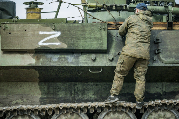 Egy ukrán katona egy megszerzett orosz páncélost vizsgál, aminek az oldalán látható az orosz háborús szimbólummá vált Z betű – Fotó: Celestino Arce / NurPhoto / AFP