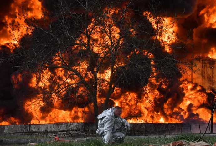Egy tűzoltó próbálja eloltani a tüzet egy olajraktárban a donyecki Makiivkában – Fotó: Alexey Kudenko
