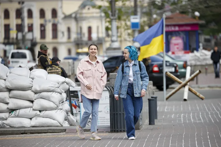 Fiatalok sétálnak el egy katonai barikád mellett a kijevi Függetlenség téren, 2022. május 1-jén – Fotó: Dogukan Keskinkilic / Anadolu Agency / AFP