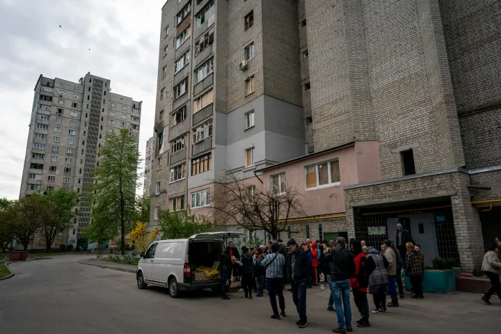 Civilek kapnak segélycsomagokat a lakóházuk előtt, Harkivban, 2022. április 29-én – Fotó: Wolfgang Schwan / Anadolu Agency / Getty Images