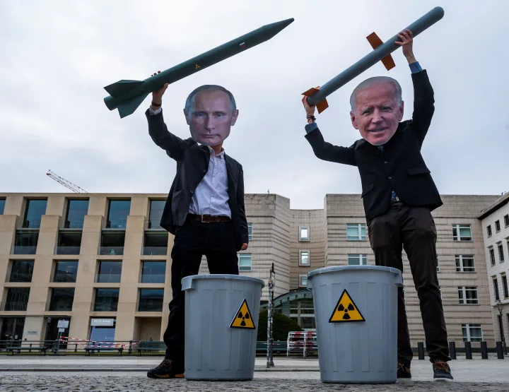 Vlagyimir Putyin orosz elnöknek és Joe Biden amerikai elnöknek öltözött békeaktivisták pózolnak nukleáris rakétákkal az USA berlini nagykövetsége előtt 2021. január 29-én, a nukleáris leszerelésről szóló megegyezéseket sürgető akcióban – Fotó: John MacDougall / AFP