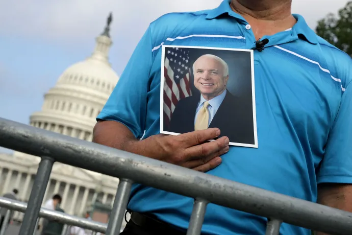 Egy férfi a 81 évesen meghalt szenátor fotóját tartva vár John McCain búcsúztatójára 2018. augusztus 31-én – Fotó: Chip Somodevilla / Getty Images North America / Getty Images via AFP