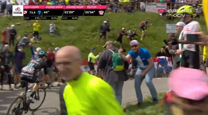 Mizsur András telexes pólóban, mögötte Fehér János szurkol a Giro d'Italia 16. szakaszán, a Mortirolo-hágón – Forrás: Eurosport Player