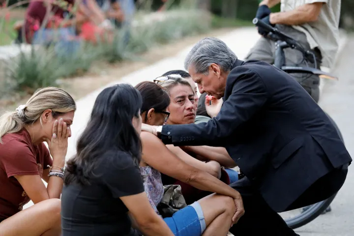 Gustavo Garcia-Siller, a San Antonio érsekség érseke vigasztalja a családokat a Willie de Leon Közösségi Központ előtt, ahová a diákokat a Robb Általános Iskolából szállították a lövöldözés után – Fotó: Marco Bello / Reuters