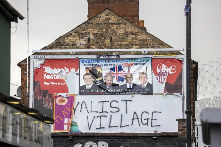 Transzparens egy tűzfalon Belfast "The Village" elnevezésű, erős unionista közösséggel rendelkező részén. A plakáton egy üzenet áll Maros Sefcovicnak, az Európai Bizottság alelnökének, Boris Johnson brit miniszterelnöknek, Joe Biden amerikai elnöknek és Simon Coveney ír külügyminiszternek, hogy válasszanak a nagypénteki megállapodás vagy az északír jegyzőkönyv között – Fotó: Liam McBurney / PA Images / Getty Images