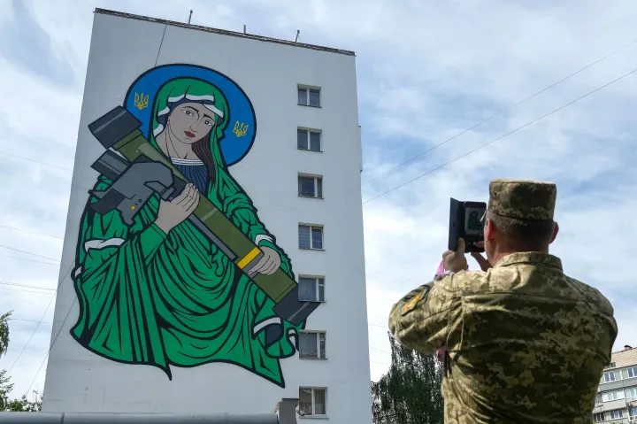 Egy ukrán katona fényképezi a "Szent Javelin" falfestményt, amelyet 2022. május 25-én avattak fel Kijevben – Fotó: Christopher Furlong / Getty Images