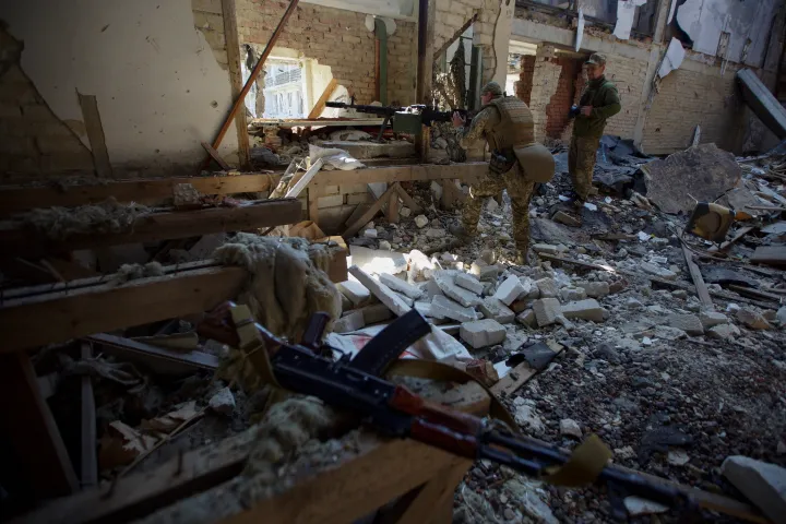 Ukrán katonák a Donyeck megyei Marinka egyik épületének romjai között – Fotó: Anna Kudriatseva / Reuters