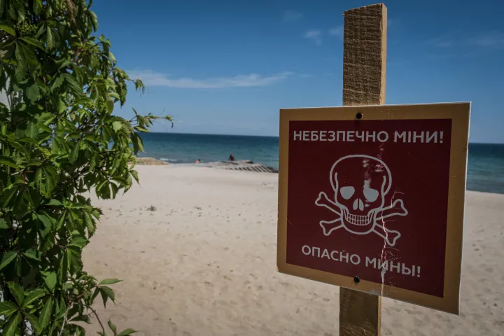 Aknaveszélyre figyelmeztető tábla az odesszai tengerparton – Fotó: Adri Salido / Anadolu Agency / AFP