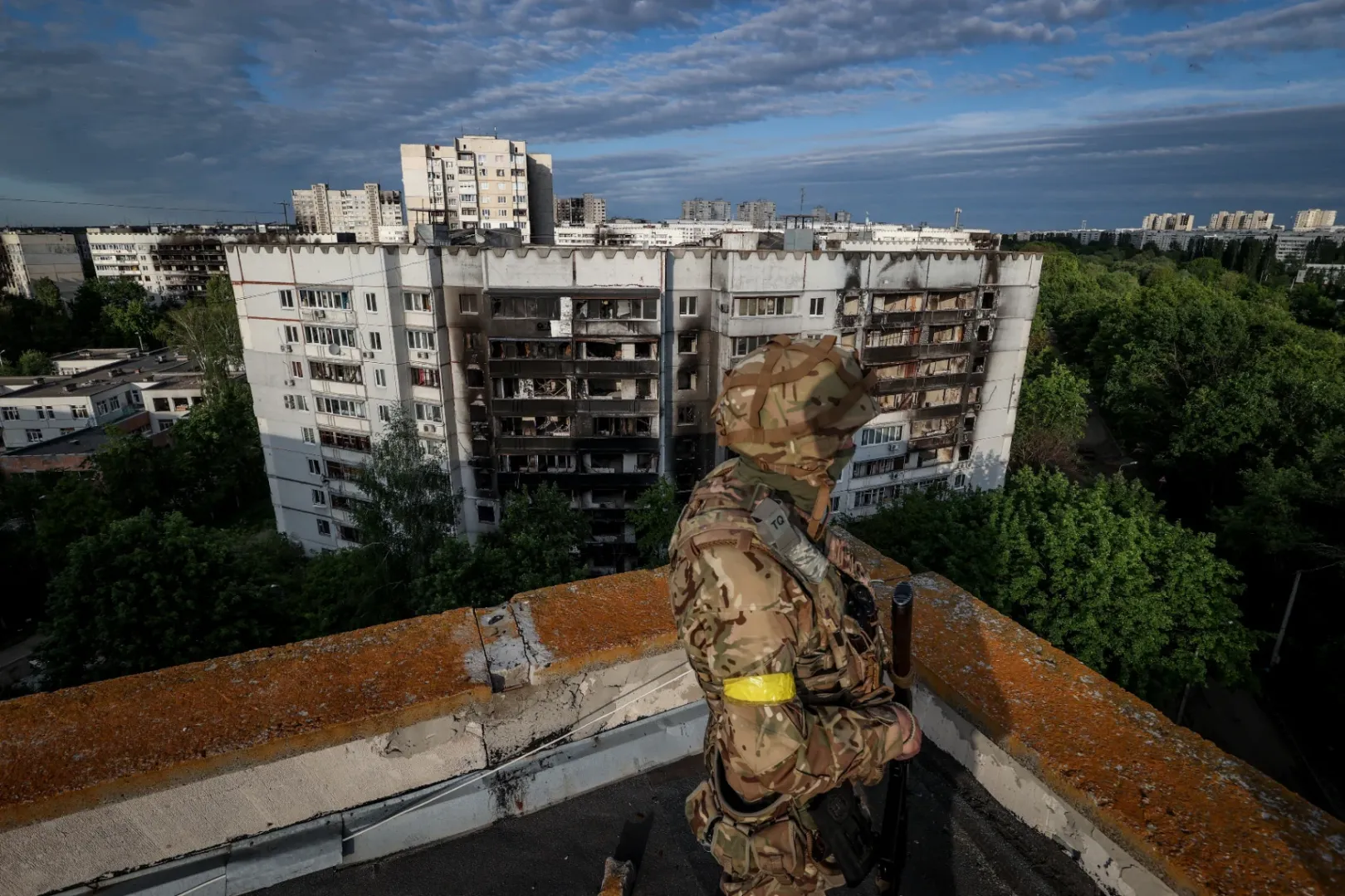 Őrt álló ukrán katona az egykor 450 ezres Szaltyivka északi részén egy épület tetején 2022. május 31-én – Fotó: Huszti István / Telex