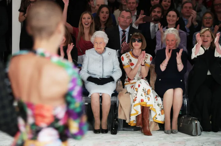 A királynő, a Brit Divat Tanács igazgatója, Caroline Rush és Angela Kelly egy Richard Quinn divatbemutatón, ahol a tervező a II. Erzsébet királynő-díj a brit formatervezésért díjat vehette át az uralkodótól 2018. február 20-án – Fotó: Yui Mok / AFP