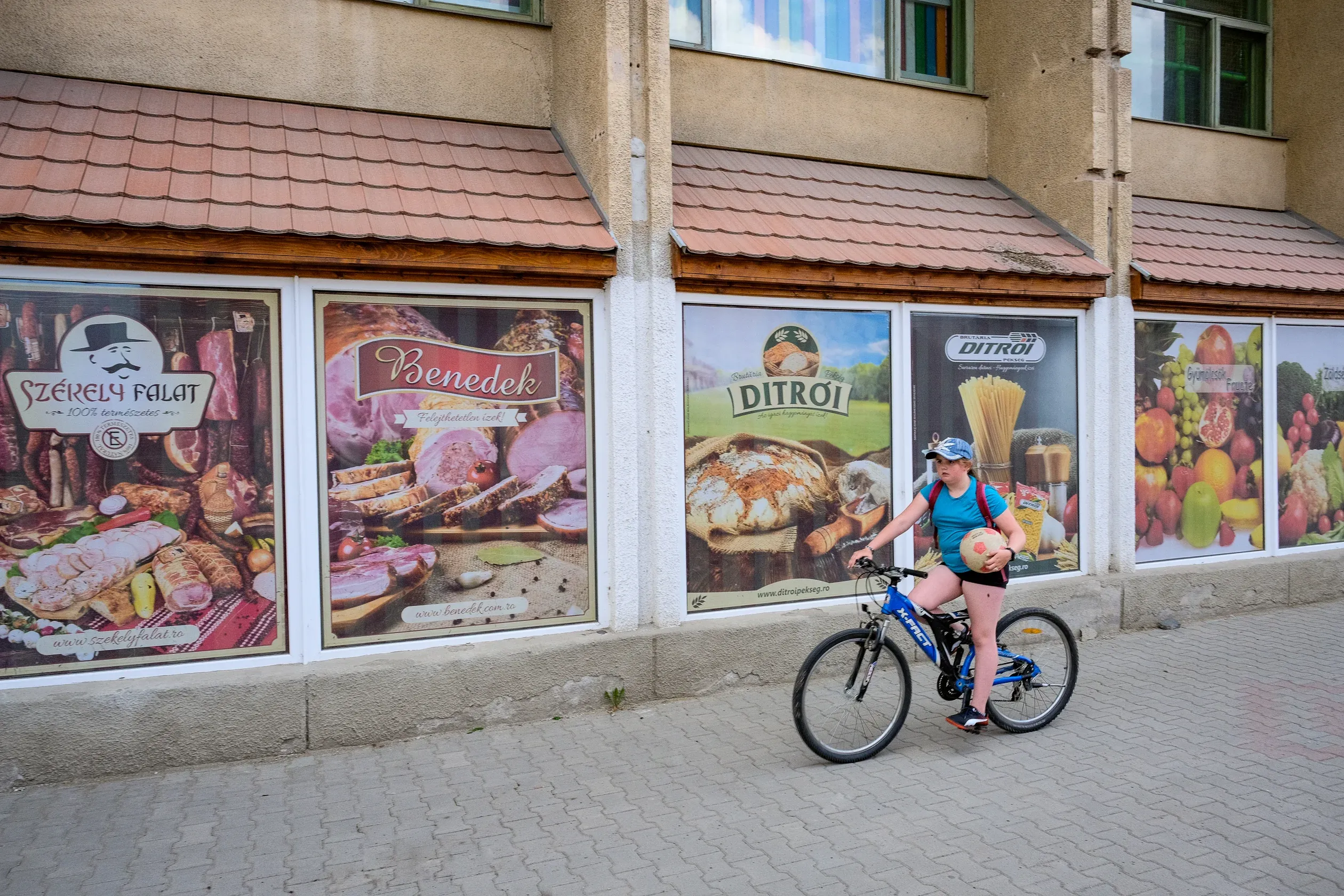 A Ditrói pékség reklámja a község központjában lévő élelmiszerüzlet ablakán – Fotó: Márkos Tamás/Transtelex
