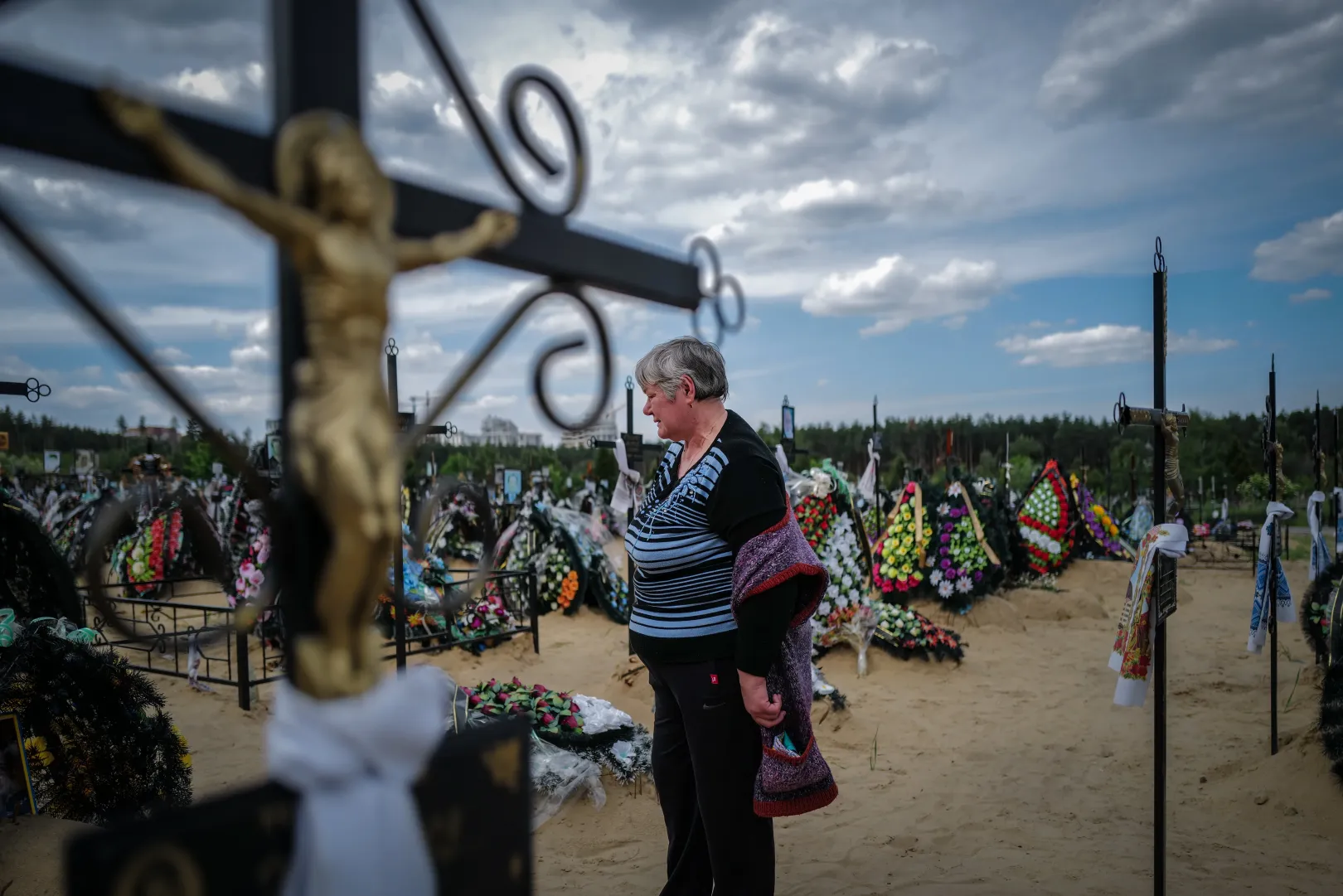 Egy megölt szomszéd sírja előtt álló asszony Irpinyben – Fotó: Huszti István / Telex