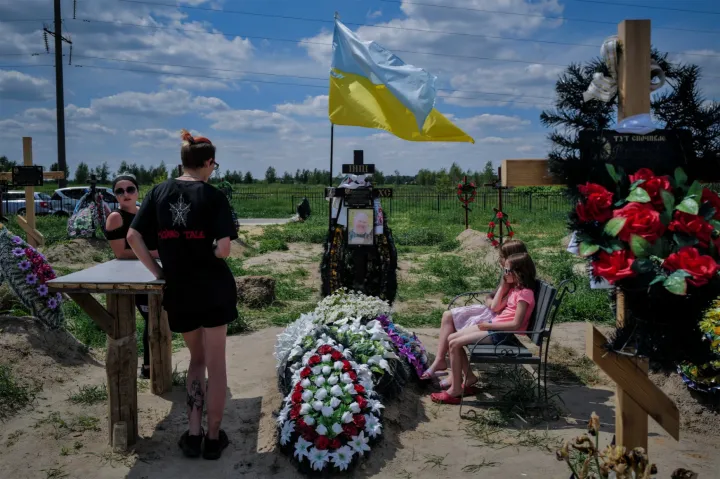 Alekszandr Blagodatnij sírjánál családja, a három hétig tartó orosz megszállás alól felszabadult Bucsában – Fotó: Huszti István / Telex