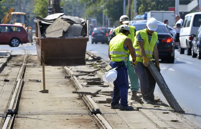 Munkások bontási hulladékot pakolnak egy konténerbe az 1-es villamos vonalának felújításán az Egressy út és Hungária körút kereszteződésében, 2014 júniusában – Fotó: Máthé Zoltán / MTI