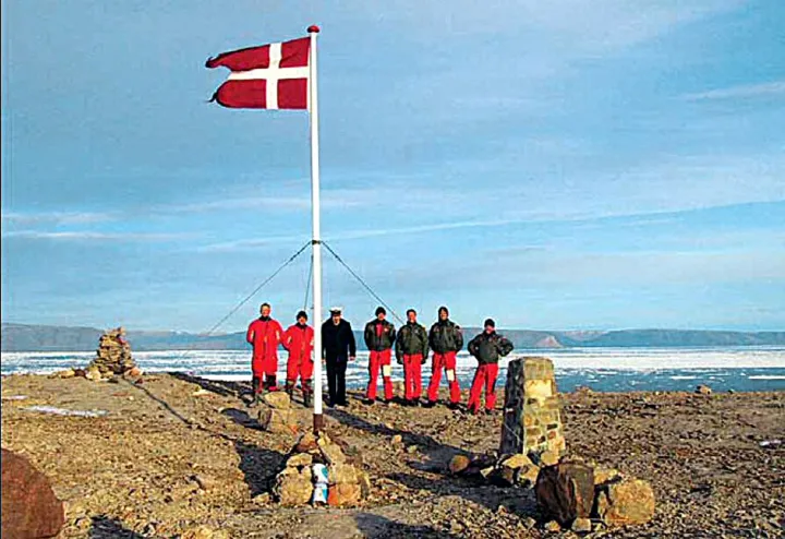Katonák felhúzzák Dánia zászlaját a szigeten 2005. július 25-én, tiltakozásul a kanadai védelmi miniszternek a szigeten tett korábbi látogatása ellen – Fotó: Royal Danish Navy / AFP