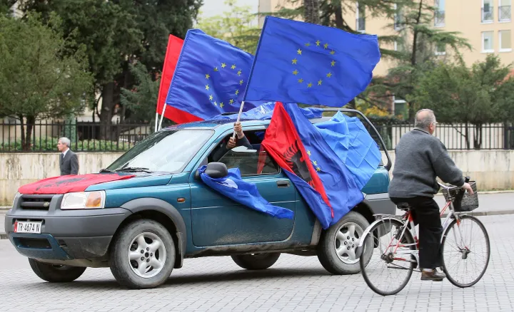 Albánok zászlókat lengetnek egy autóból 2010. november 8-án Tiranában, hogy üdvözöljék az Európai Unió döntését, amely szerint a vízummentesség kiterjesztése történelmi döntés, amely egy lépést jelent az európai jövő felé – Fotó: Gent Shkullaku