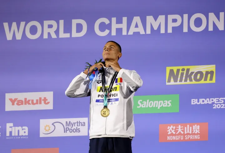 Az aranyérmes Popovici ünnepel a dobogón, miután megnyerte a férfi 200 méteres gyorsúszás döntőjét a budapesti világbajnokságon – Fotó: Antonio Bronic / Reuters