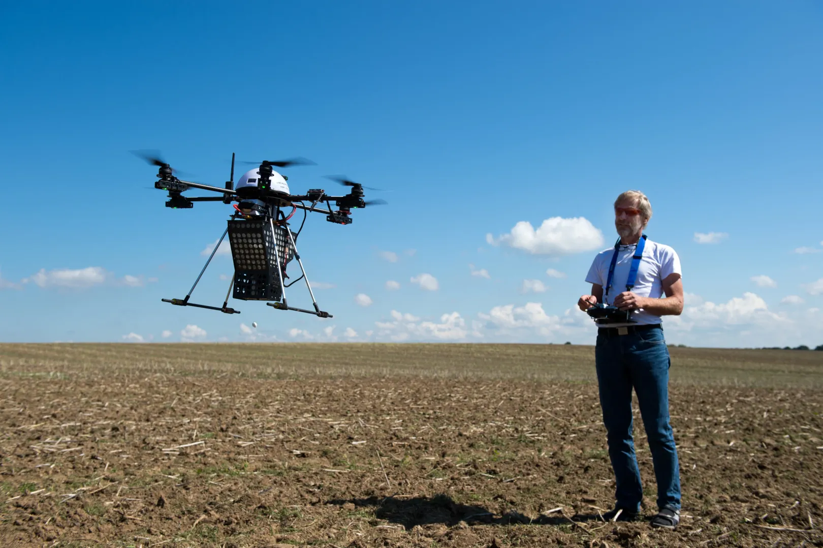 Egy férfi darázslárvákkal megrakott drónt reptet. A GPS-irányítású eszköz egy előre meghatározott útvonalon szórja el az európai kukoricabogár elleni rakományát a németországi Riemsdorf közelében – Fotó: Arno Burgi / DPA / AFP