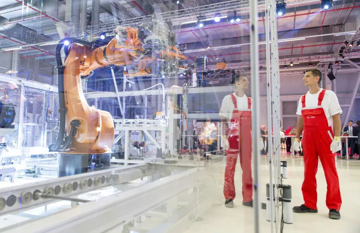 Dolgozó egy motor-összeszerelő robotnál az Audi Hungaria Zrt. elektromos motorokat gyártó győri üzemcsarnokában az avatás napján, 2018. július 24-én – Fotó: Krizsán Csaba / MTI