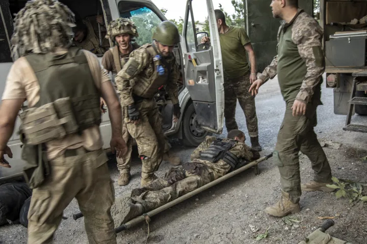 Ukrán katonai orvosok egy katonát mentenek ki az orosz ágyúzás során a Sziverszk melletti egyik csatamezőről – Fotó: Narciso Contreras / Anadolu Agency / AFP