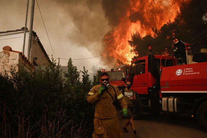 Tűzoltó az Athén Vúla nevű negyedében pusztító erdőtűz mellett – Fotó: Jánisz Koleszidisz / EPA / ANA-MPA / MTI