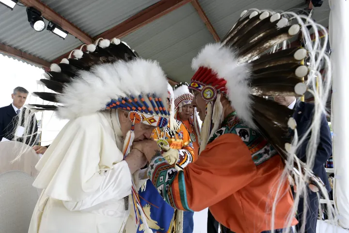 Ferenc pápa fejdíszt kap a kanadai őslakos közösségek vezetőitől – Fotó: Handout / VATICAN MEDIA / AFP 