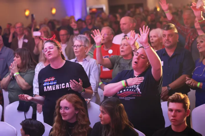 Az emberek imát énekelve táncolnak a pennsylvaniai republikánus kormányzójelölt, Doug Mastriano választási partiján 2022. május 17-én a pennsylvaniai Chambersburgban – Fotó: Michael M. Santiago / Getty Images / AFP