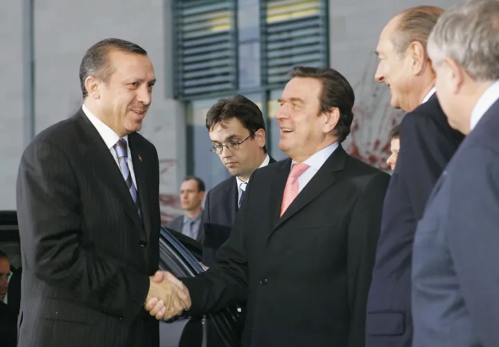 Gerhard Schröder német kancellár üdvözli a francia és német kormány csúcstalálkozójára Berlinbe érkező Recep Tayyip Erdoğan török miniszterelnököt, 2004. október 26-án, mellettük Jacques Chirac francia elnök és Jean-Pierre Raffarin francia miniszterelnök. A találkozón többek között Törökország európai uniós tagsági kérelméről tárgyaltak – Fotó: Sean Gallup / Getty Images