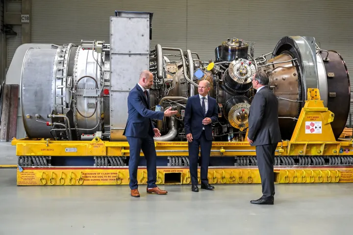Olaf Scholz német kancellár és Christian Bruch (b), a Siemens Energy német energetikai vállalat vezérigazgatója az Északi Áramlat 1 Kanadában megjavított turbinájával a Siemens mülheimi üzemében, 2022. augusztus 3-án. Scholz szerint nincs akadálya a turbina Oroszországba szállításának, amelynek hiányára hivatkozva a Gazprom orosz vállalat ötödére csökkentette az Északi Áramlat 1-en Németországba szállított földgáz mennyiségét – Fotó: Sascha Steinbach / EPA / MTI