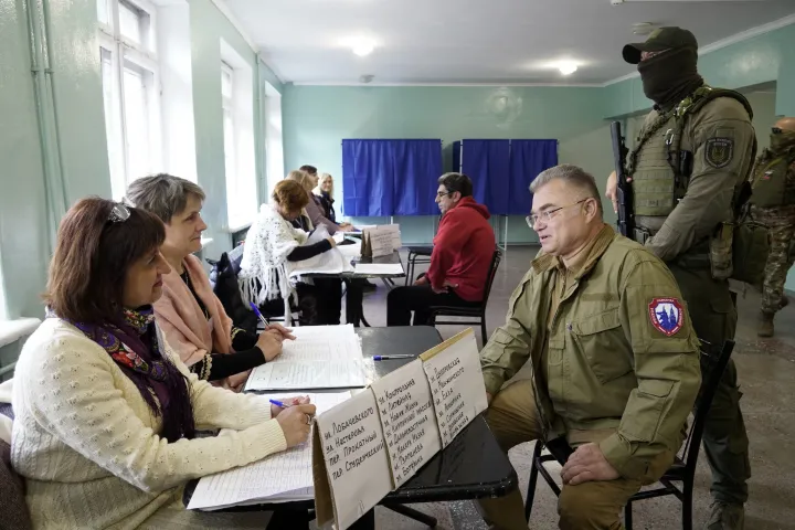 Konsztantin Ivacsenkó Mariupol oroszország által támogatott ügyvivő polgármestere fegyveres kísérettel látogatott meg egy szavazóhelyiséget – Fotó: Stringer / AFP