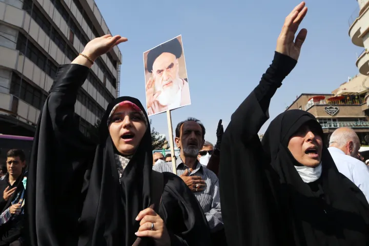 Kormánypárti tüntetők Khomeini ajatollah, a forradalom utáni tíz évben Irán legfelsőbb vezetőjének képével Teheránban, Mahsza Amini halála után, 2022. szeptember 23-án – Fotó: Fatemeh Bahrami / Anadolu Agency / AFP
