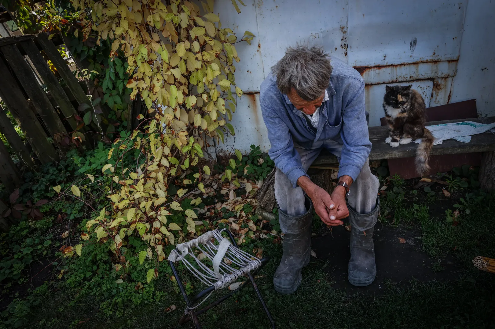 Kurilivkai portáján fásult fáradtságban ülő férfi. A háza legalább lakható, bár érte már találat – Fotó: Huszti István / Telex