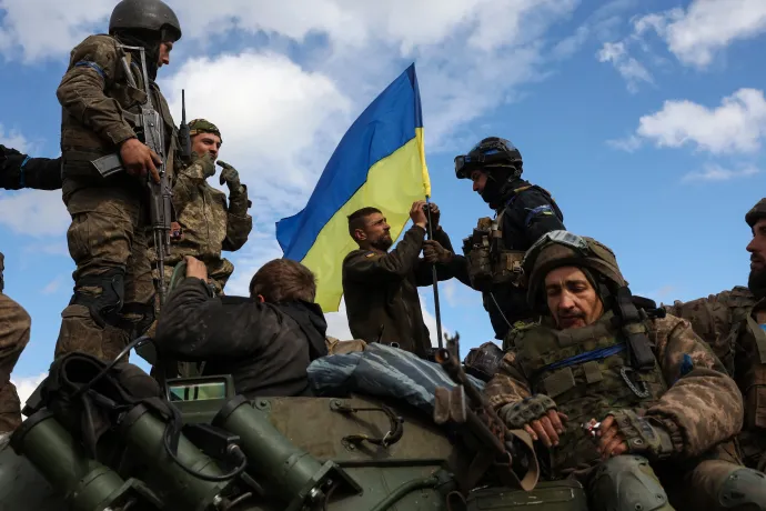Ukrán katonák zászlót erősítenek egy páncélozott csapatszállítóra a donyecki területen visszafoglalt Lyman közelében – Fotó: Anatolii Stepanov / AFP