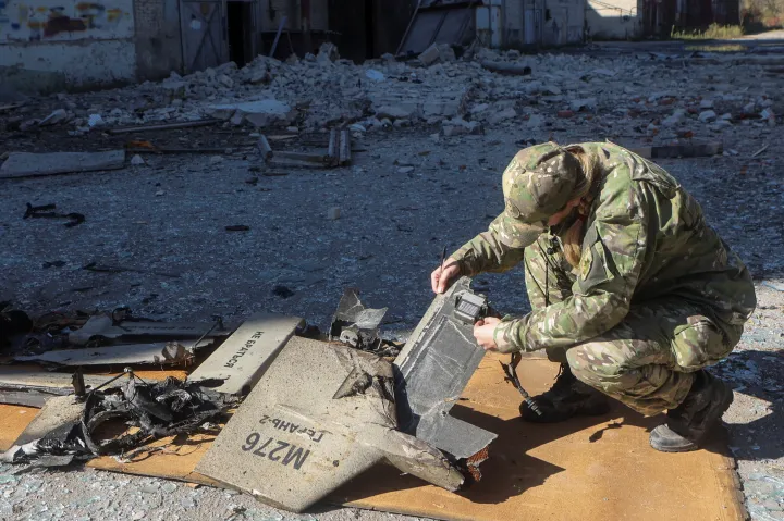 Ukrán rendőr egy Sahíd–136 drón maradványait vizsgálja, miután légitámadás ért egy harkivi üzemanyagraktárat 2022. október 6-án – Fotó: Vjacseszlav Madiyevszkij / Reuters