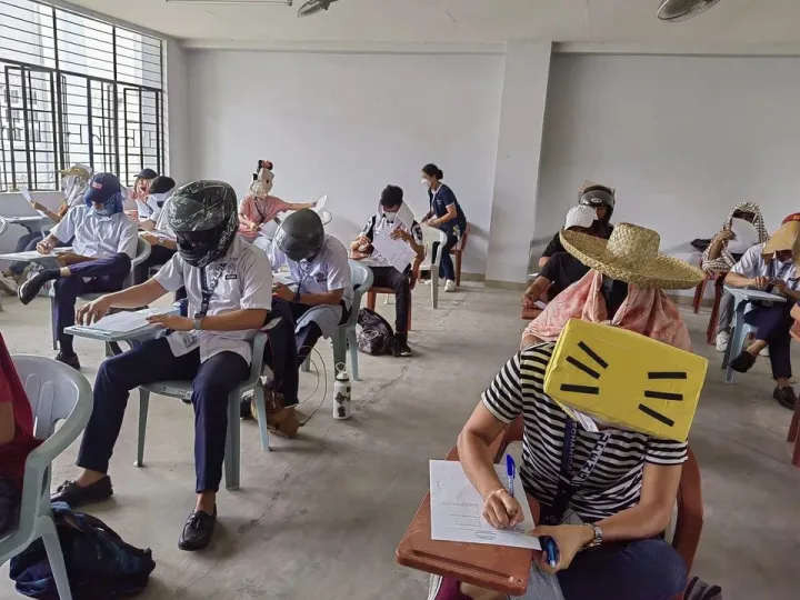 A fülöp-szigeteki egyetemisták a puskázást megakadályozó fejfedőkben – Fotó: Mary Joy Mandane-Ortiz,