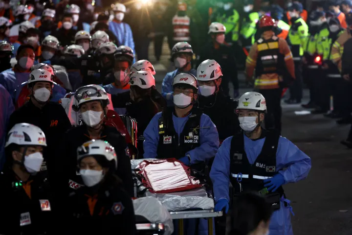 Mentőmunkások hordágyakkal várakoznak a holttestek elszállítására – Fotó: Kim Hong-ji / Reuters