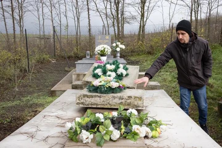 Demkó Gábor a novaji temetőben, szovjet katonák sírjánál, amelynek eldőlt a sírköve. A rendőrségi vizsgálat a rongálás eshetőségét is mérlegeli, de kőművesek szerint nem volt jól rögzítve a sírkő, és a sírrongálásokkor többnyire feliratokat, jeleket hagynak a rongálók, itt viszont semmi ilyet nem találtak. Ráadásul a szovjet sírkő ledőlésekor a szeles időben a temető más sírjaiban is kár keletkezett, így nagyon valószínű, hogy nem vandálok tették – Fotó: Hevesi-Szabó Lujza / Telex