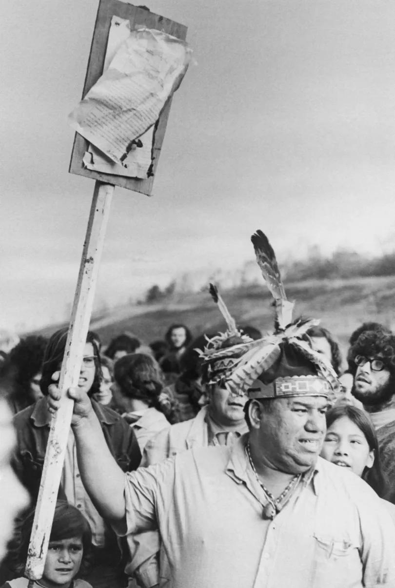 Első kép: Amerikai őslakos lány „indián amerikai föld” feliratú táblát fest az egykori szövetségi börtön épületének falára az Alcatraz-szigeten, 1969-ben – Második kép: Egy indián rezervátumon keresztülhaladó út ellen tüntető tuszkaróra őslakos a Niagara-vízesés közelében, 1971-ben – Fotó: Bettmann / Getty Images