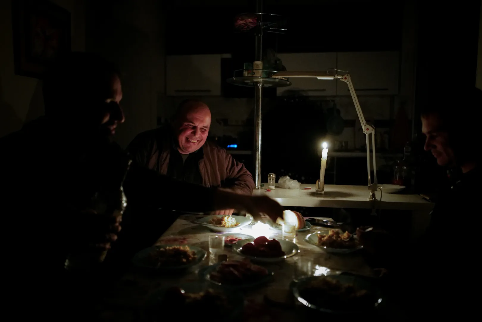 A candlelit dinner during a power outage. Dmitri, the vegetable farmer has been survining on his savings for months – Photo: István Huszti / Telex