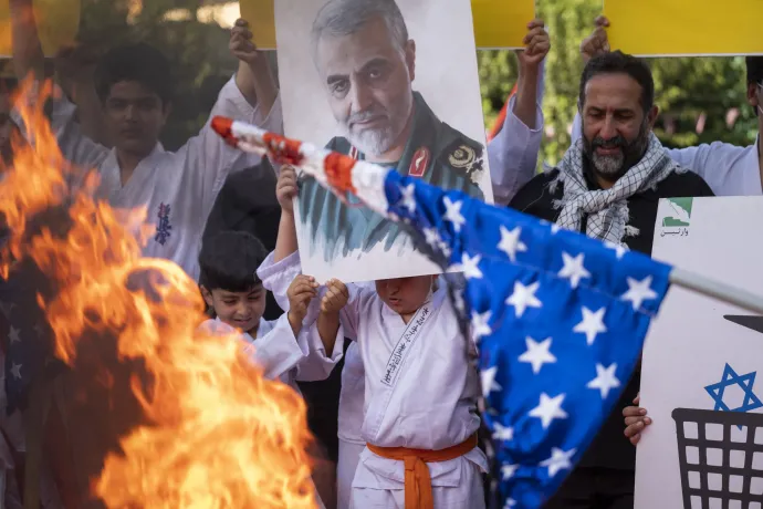Iráni tüntetők égetnek amerikai zászlót Kászim Szolejmani portréja előtt Teheránban 2022. augusztus 9-én – Fotó: Morteza Nikoubazl / NurPhoto / AFP