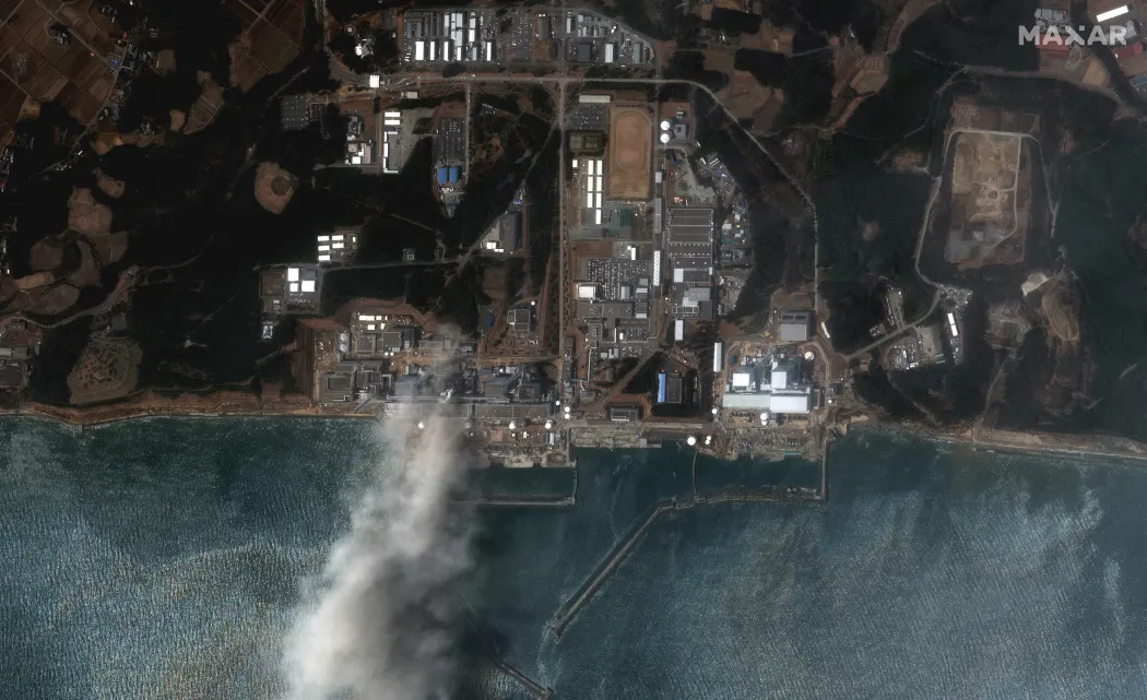 A Maxar Technologies műholdképén a Fukusima Daiicsi atomerőmű égő reaktorából felszálló füst látható 2011. március 14-én, három nappal azután, hogy a területet ért földrengés és szökőár nukleáris katasztrófát okozott – Fotó: Maxar Technologies / AFP