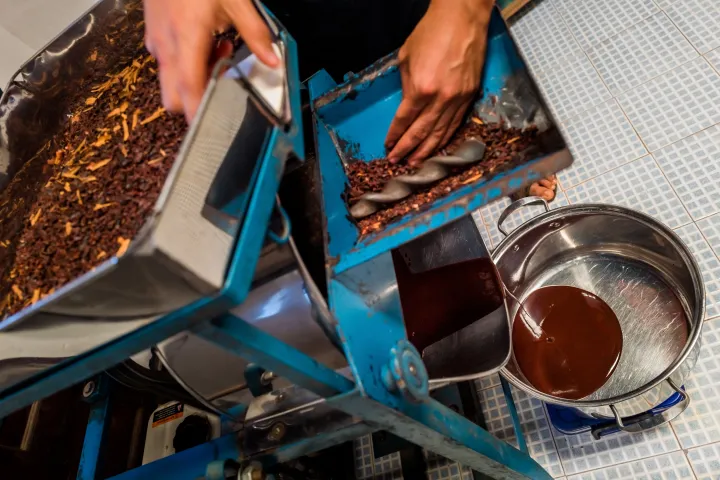 Friss kakaólikőr folyik ki a kézműves csokoládégyártó gépből egy a mexikói Xochistlahuacában. Dél-Mexikó egyes területein az őslakos közösségek még mindig életben tartják a kézzel készített csokoládé ősi hagyományát, amely olyan kultúrákban született, mint az olmékok, a maják és az aztékok – Fotó: Jan Sochor / Getty Images