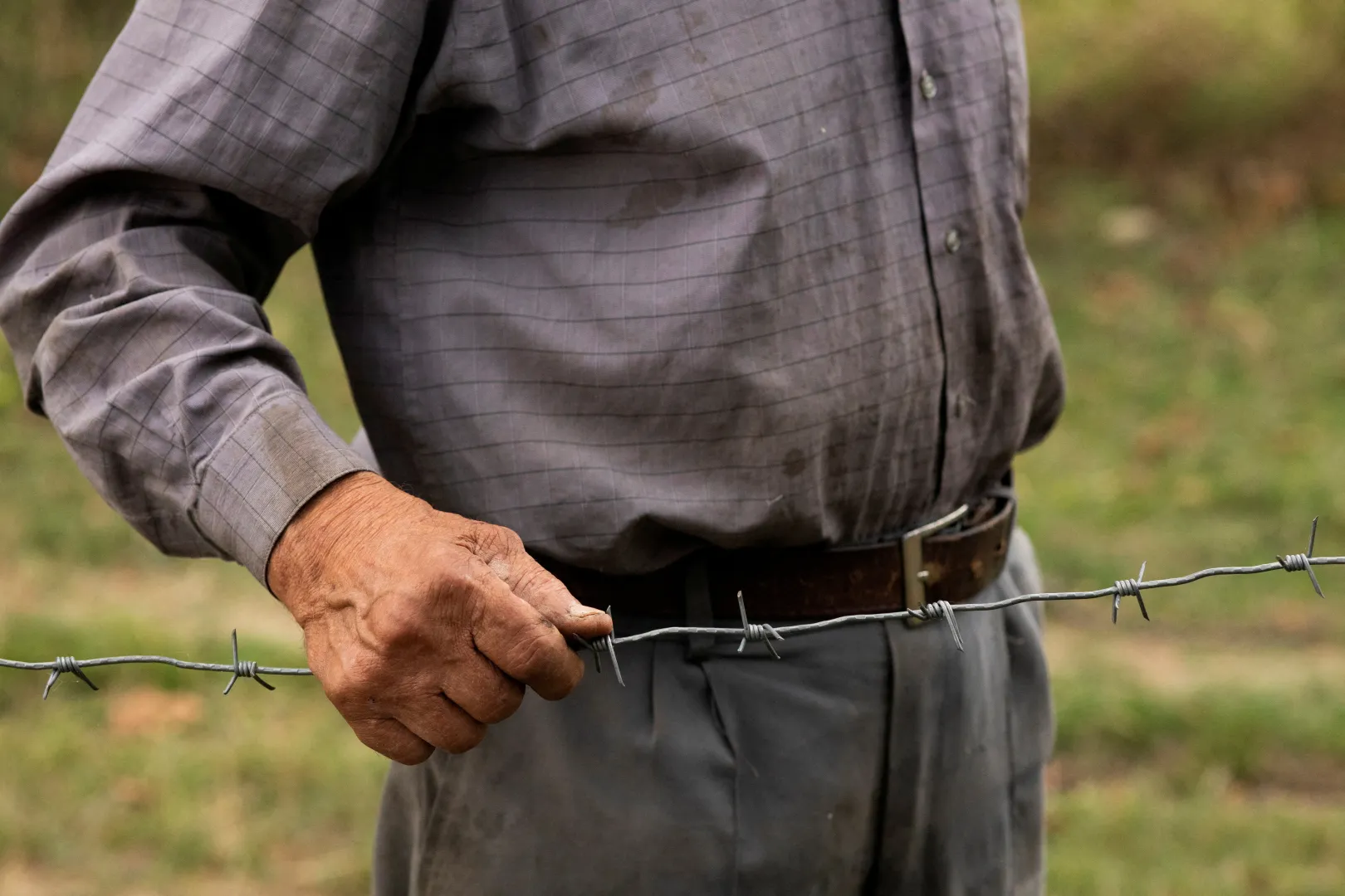 A 84 éves Data Vanisvili megérinti a szögesdrótból épített határkerítést – Fotó: Daro Sulakauri / Reuters
