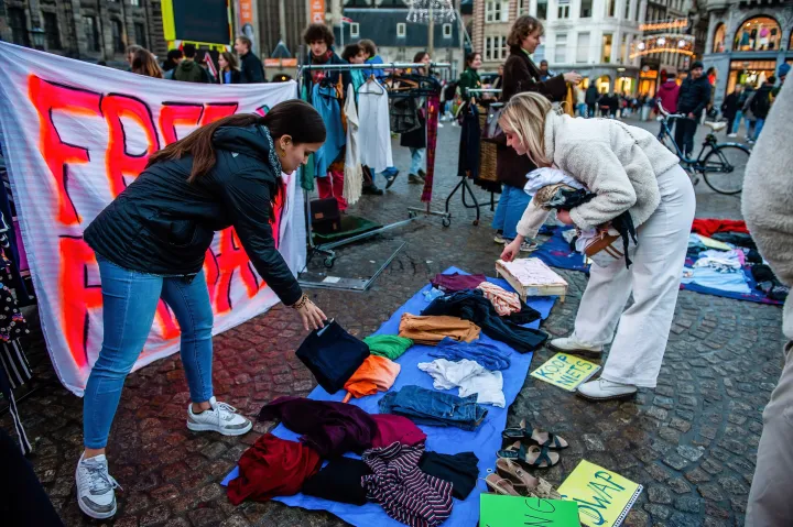 Klímaaktivisták által a túlfogyasztás ellen szervezett demonstráció 2022 novemberében, Amszterdamban, amikor is több száz használt ruhát helyeztek el, amelyeket az emberek ingyen elvihettek vagy ruhát cserélhettek – Fotó: Ana Fernandez / SOPA Images / LightRocket / Getty Images
